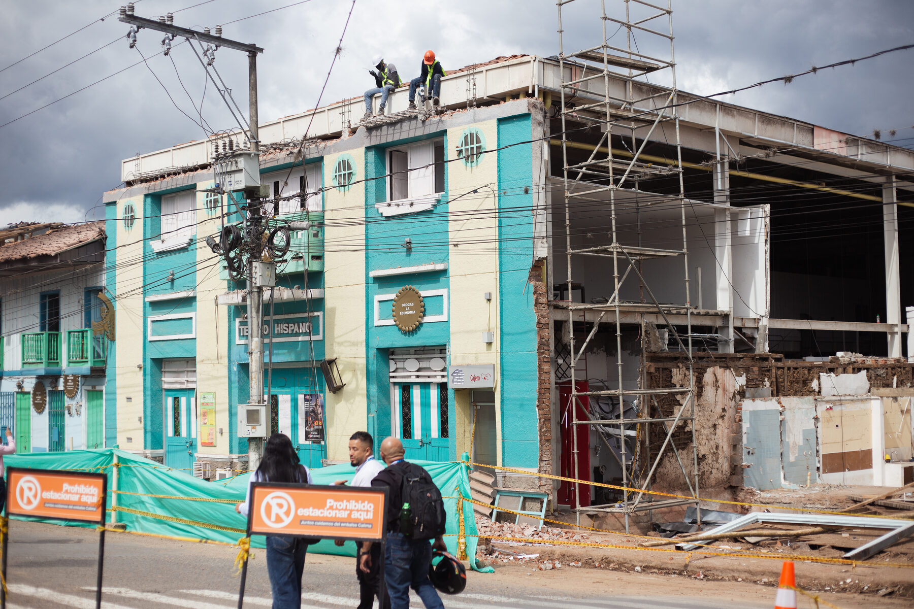 Scaffolding and workers on the roof of the damaged Teatro Hispano building in the town centre